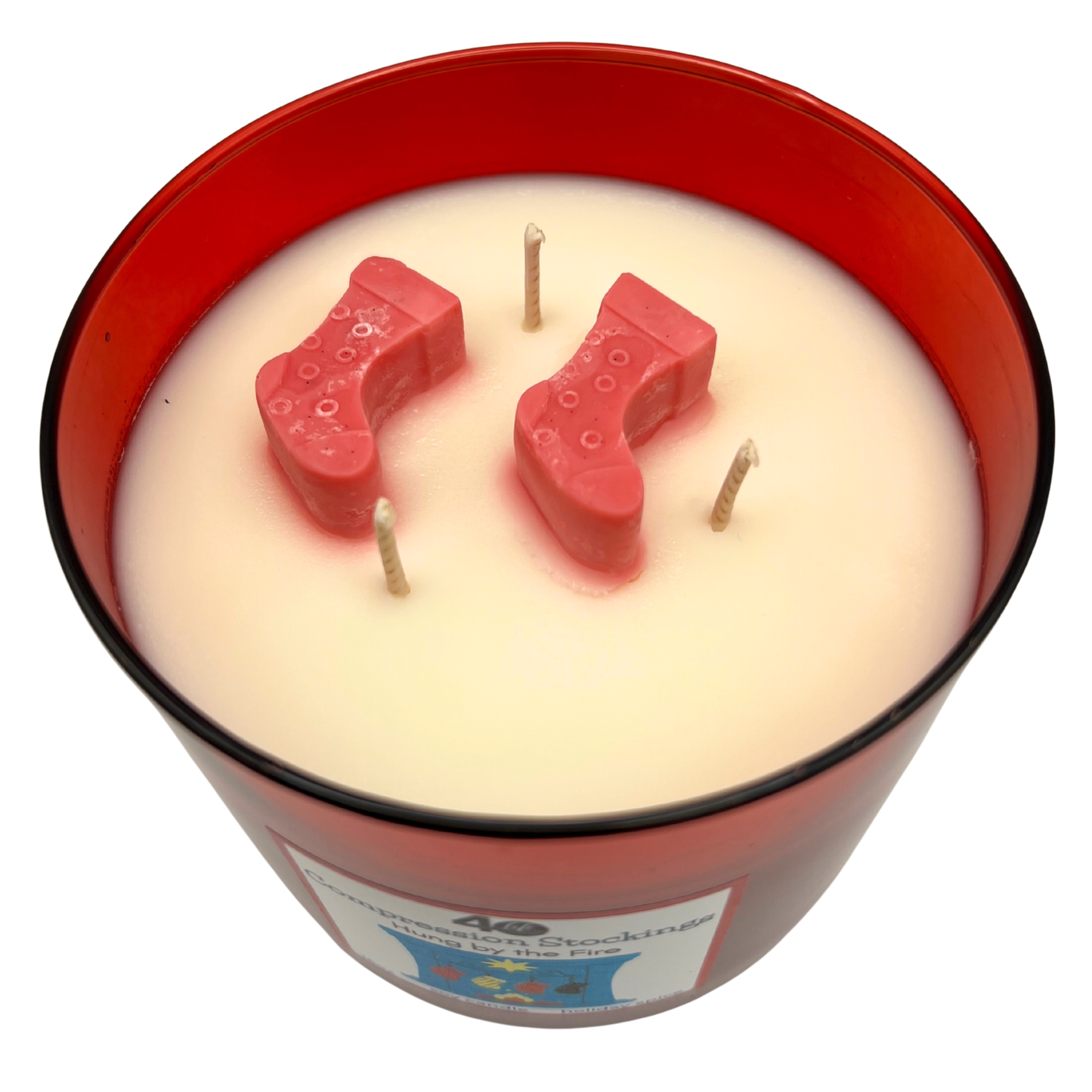 Candle in a red container with Christmas stocking shapes on a white background