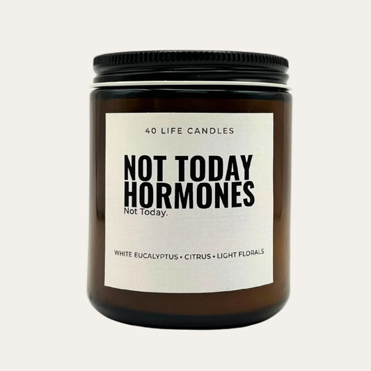 candle with funny label and scents in amber jar on cream background.