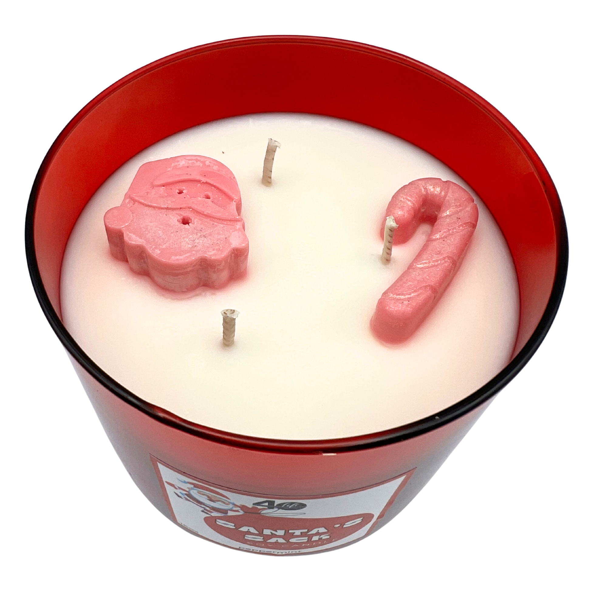 Candle in a red container with pink candy cane and leaf-shaped wicks on a white background