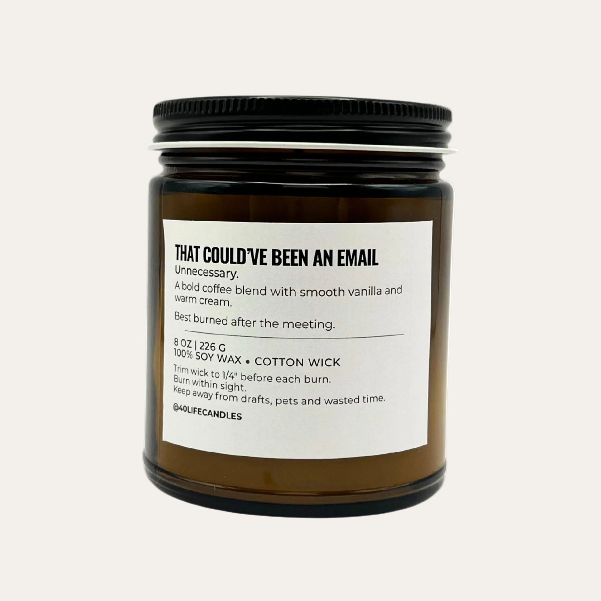 Soy candle in amber jar with directions label on cream background.