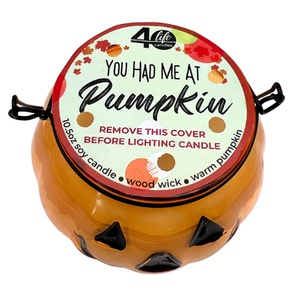 Pumpkin-shaped candle with a decorative label on a white background