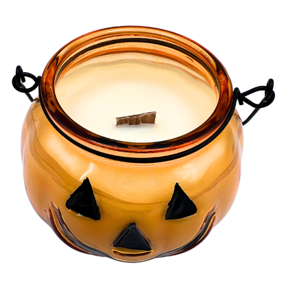 Halloween-themed candle in a glass jar with black triangle decorations on a white background