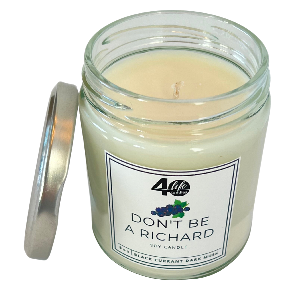 Long-lasting soy candle in a reusable glass jar with a silver metal lid resting beside the jar. Candle label has black berries and a green leaf on it.