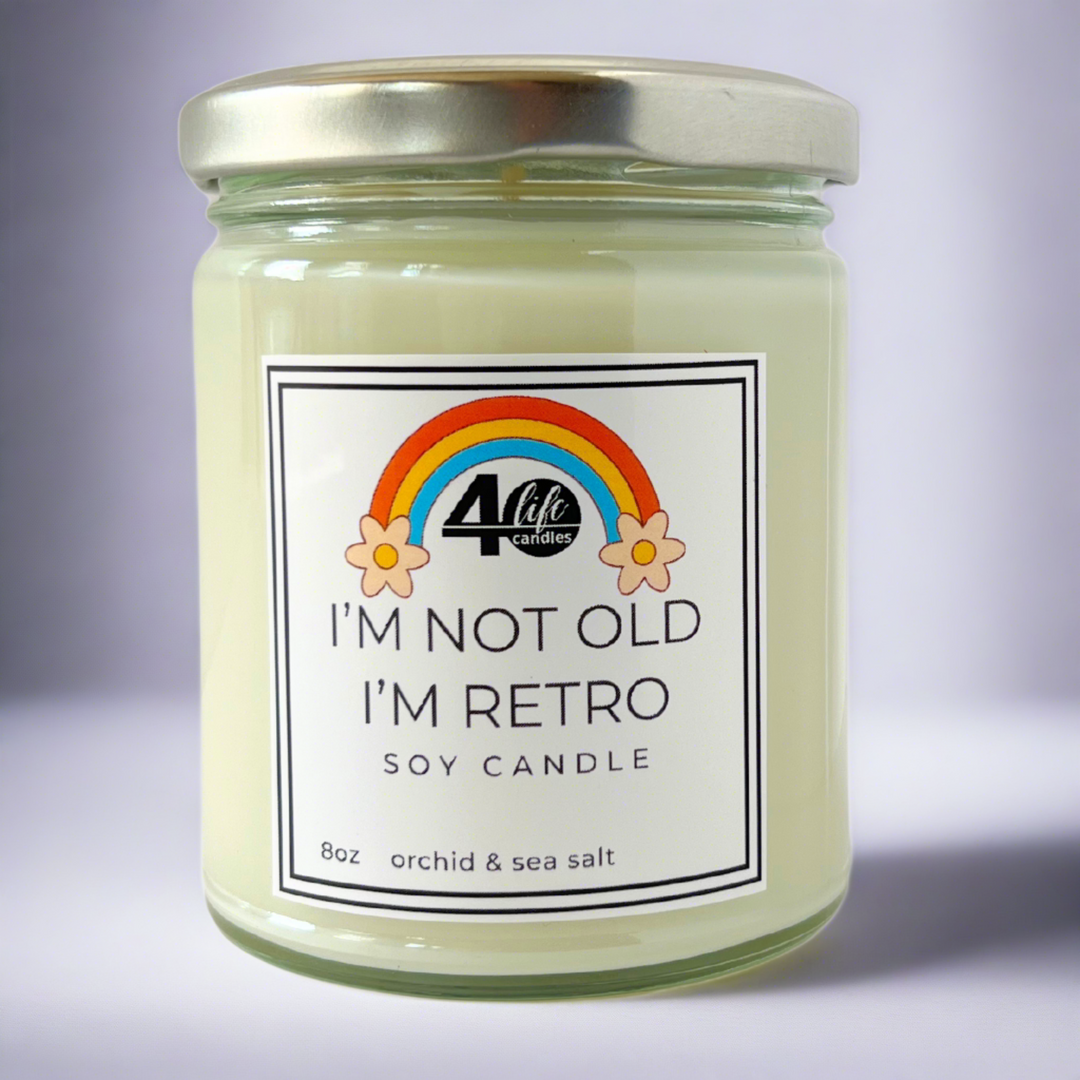 I'm not old I'm Retro soy candle jar with silver lid on a white background. Rainbow with flower on each side of it.